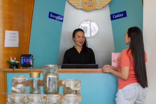 a man and a woman standing at a counter at The Auto Place in Ban Sam Kong