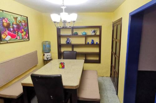 a dining room with a table and chairs in a room at Linda casa azul ubicada en el corazón de Pátzcuaro in Pátzcuaro