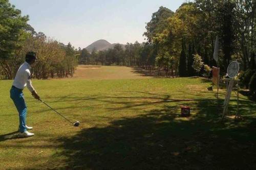 a man is playing golf in a field at Primavera en Jarabacoa-contacto con la naturaleza in Jarabacoa