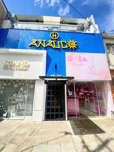 a store with a blue building with a sign on it at Hotel Anauco in Bucaramanga