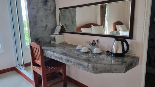eine Theke aus Stein in einem Zimmer mit Spiegel in der Unterkunft PawPaw Resort in Koh Samui 