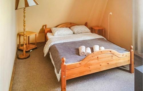 a bedroom with a wooden bed with two pillows at Stunning Home In Lidzbark Warminski With House Sea View in Lidzbark Warmiński