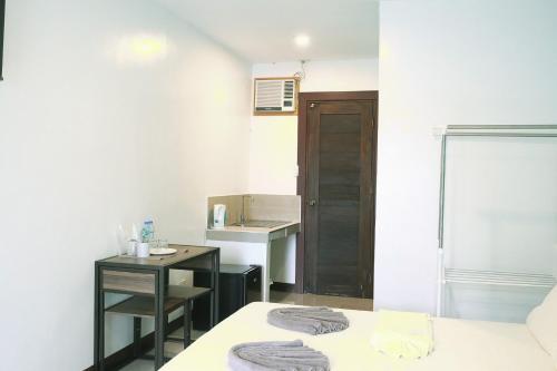 a room with a bed and a sink and a desk at Casa D’ Hiyas Homestay Panglao, Bohol in Panglao