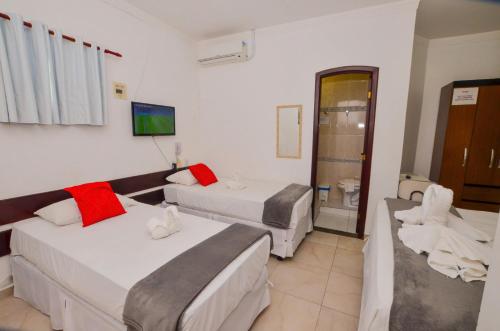 a hotel room with two beds and a bathroom at Hotel Diamante Negro in Salvador