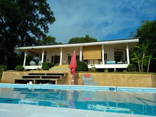 une maison avec une piscine et un parasol rouge dans l'établissement Baan Zourite seaview villa, à Ko Mak
