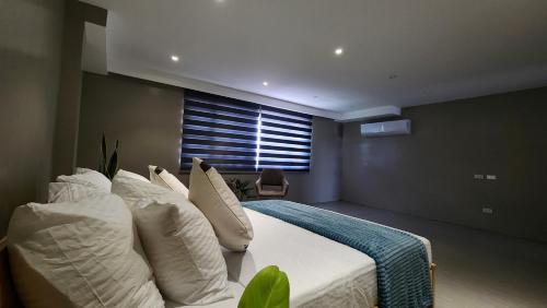 a bedroom with a bed with white pillows and a window at Spacious 5-bedroom, 4-bath townhouse in Legazpi City in Legazpi