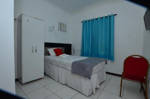a bedroom with a bed and a blue curtain at Hotel Diamante Negro in Salvador