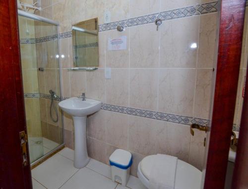 a bathroom with a sink and a toilet and a shower at Hotel Diamante Negro in Salvador