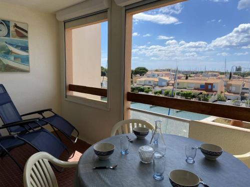 d'une table et de chaises avec vue sur un balcon. dans l'établissement 2P Cabine, 6 couchages, terrasse, parking, proche plage - Cap d'Agde - FR-1-249-149, au Cap d'Agde