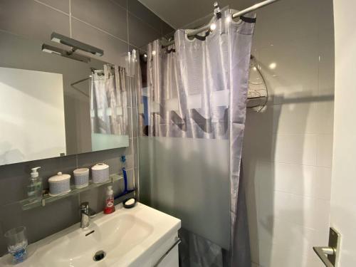 une salle de bain avec un rideau de douche et un lavabo dans l'établissement 2P Cabine, 6 couchages, terrasse, parking, proche plage - Cap d'Agde - FR-1-249-149, au Cap d'Agde