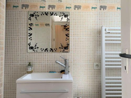 une salle de bain avec un lavabo et un miroir dans l'établissement Charmante maisonnette bretonne à 100m de la mer avec jardin, terrasse et proximité centre Trégastel - FR-1-368-26, à Trégastel