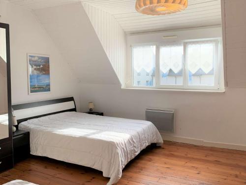une chambre blanche avec un lit et une fenêtre dans l'établissement Charmante maisonnette bretonne à 100m de la mer avec jardin, terrasse et proximité centre Trégastel - FR-1-368-26, à Trégastel