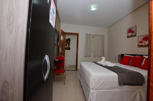 a hotel room with a bed and a red chair at Hotel Diamante Negro in Salvador