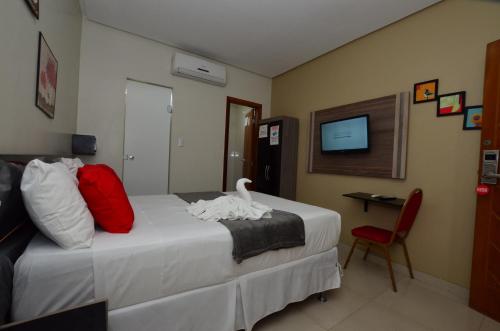a hotel room with a bed with a swan on it at Hotel Diamante Negro in Salvador
