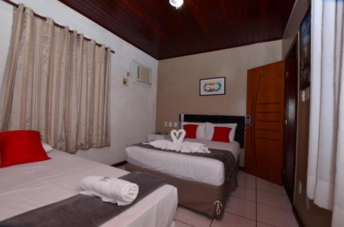 a hotel room with two beds and a window at Hotel Diamante Negro in Salvador