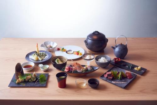 a table with plates of food and a tea pot at Sansuiso Tsuchiyu Spa in Fukushima