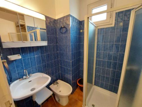 La salle de bains est pourvue de carrelage bleu, d'un lavabo et de toilettes. dans l'établissement Appartement 2 pièces cabine, 6 couchages, Grau d'Agde - FR-1-423-221, au Grau-dʼAgde
