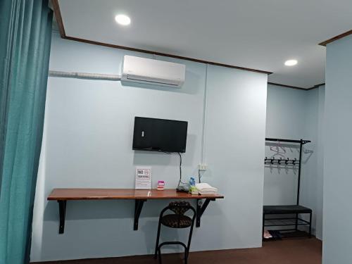 Ban Thôngchai-Tai的住宿－ເຮືອນພັກບີວີ(BV Guesthouse)，一间设有一张桌子和一台电脑的墙壁客房