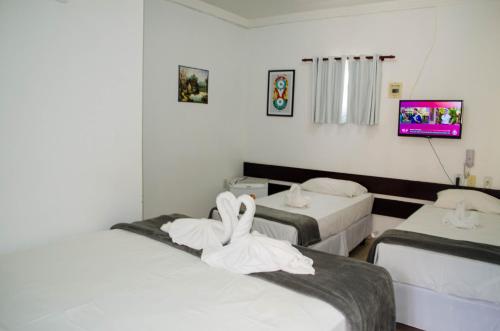 a room with two beds with towels on them at Hotel Diamante Negro in Salvador