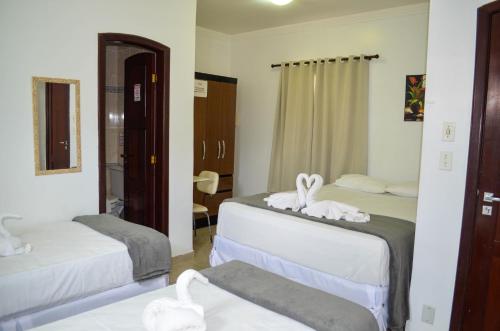 a room with two beds with towels on them at Hotel Diamante Negro in Salvador