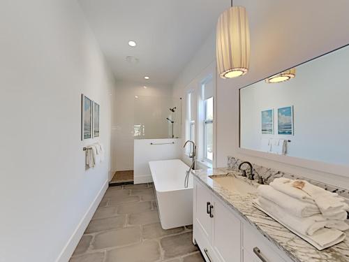 een witte badkamer met een wastafel en een spiegel bij Destination Paradise in Destin