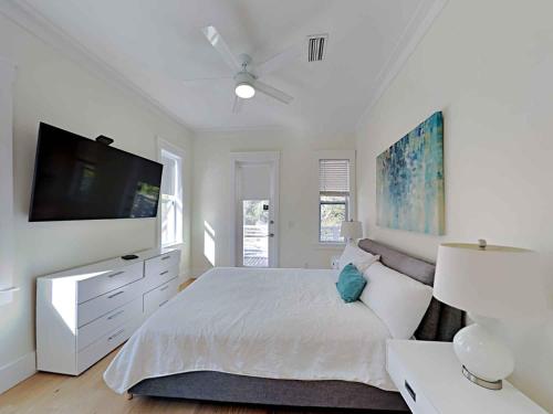 een witte slaapkamer met een groot bed en een flatscreen-tv bij Destination Paradise in Destin
