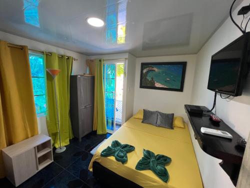 a bedroom with a yellow bed with flowers on it at Posada Ashanty in Providencia