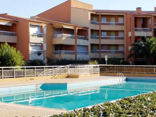 une piscine devant un immeuble dans l'établissement Studio cabine 4 pers avec terrasse, clim et parking au Lavandou - FR-1-251-431, au Lavandou