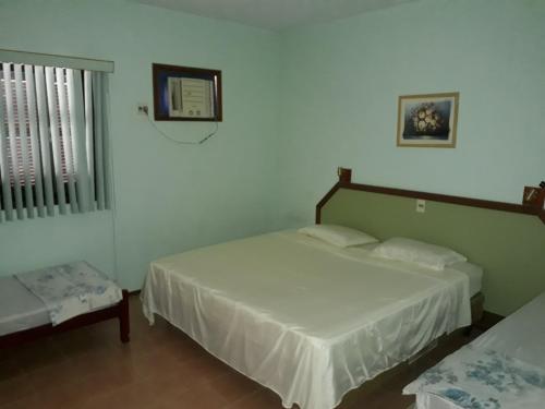 een slaapkamer met twee bedden en een raam bij Pousada Porto Aventuras in Eldorado do Sul 