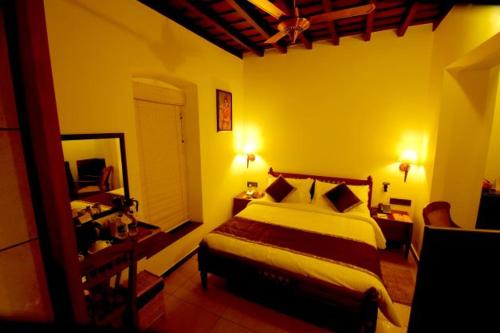 1 dormitorio con 1 cama grande y espejo en THE HILLWAY HERITAGE, en Trivandrum