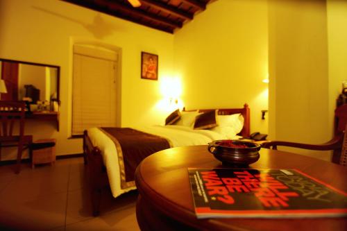 a hotel room with a bed and a table with a bowl on it at THE HILLWAY HERITAGE in Trivandrum