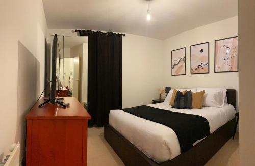 a bedroom with a bed and a television on a dresser at Great 1Bed 10 mins from East Croydon with Free WiFi in Croydon