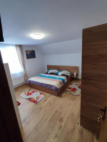 1 dormitorio con 1 cama y 2 alfombras en el suelo en Casa Daiana - Toplița, en Topliţa