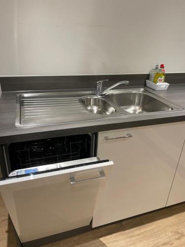 uma cozinha com um lavatório e um balcão de aço inoxidável em Great 1Bed 10 mins from East Croydon with Free parking em Croydon