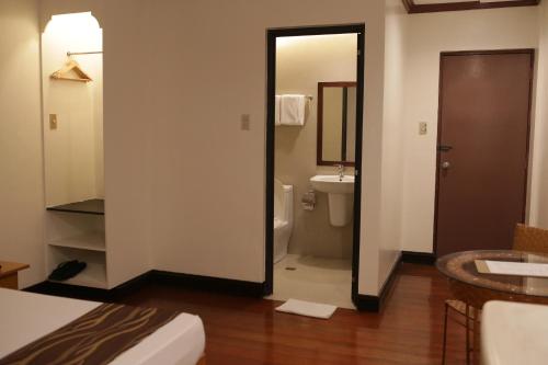 a bathroom with a toilet and a sink and a mirror at AMALFI718 HOTEL in Lipa