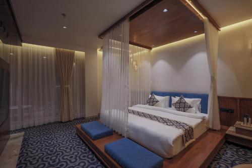 a bedroom with a large bed with a canopy at Hotel Aditya Mansingh Inn in Somnath