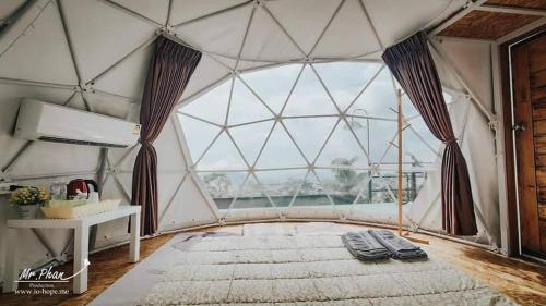 um quarto com uma grande cúpula de vidro e uma grande janela em Chill & View em Ban Huai Phai