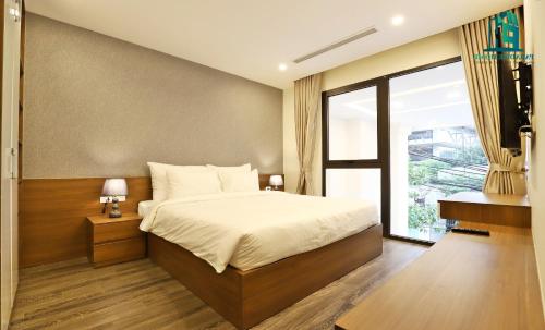 um quarto com uma cama e uma grande janela em Luxe Paradise Residence Tay Ho em Hanói