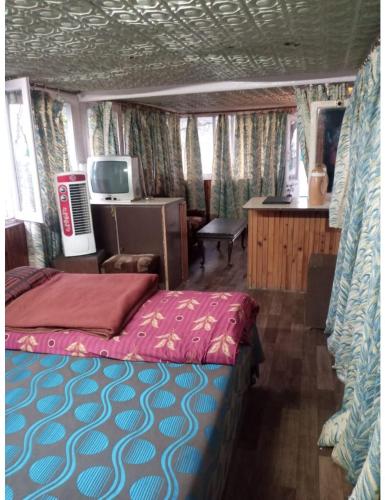 een slaapkamer met een bed en een tv. bij Moon Hotel And Restaurant,Ranikhet in Rānīkhet