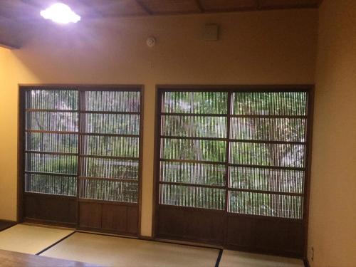 two large doors in a room with at 一客一亭の宿 遊楽 in Satsumasendai