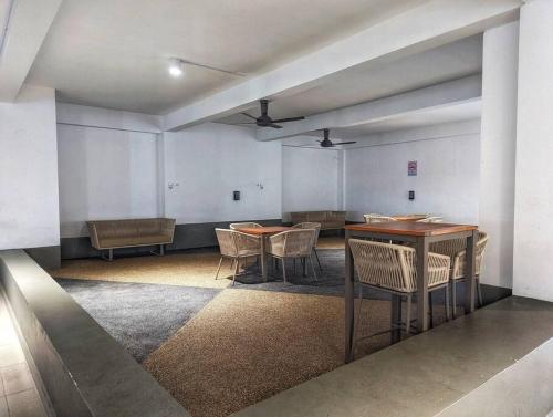 an empty room with tables and chairs in it at 3-bedroom Condo at Legasi Kampung Bharu, KL in Kuala Lumpur