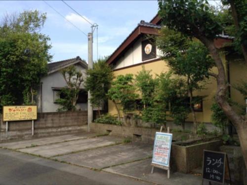 Una casa con un reloj al costado. en 一客一亭の宿 遊楽, en Satsumasendai