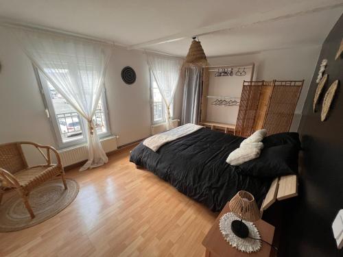 1 dormitorio con 1 cama grande y 2 ventanas en La Belle Evasion, en Gamaches
