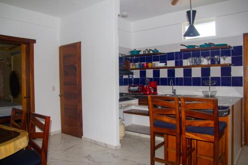 kuchnia z niebiesko-białymi kafelkami na ścianie w obiekcie Hotel Happy Beach w mieście Zihuatanejo