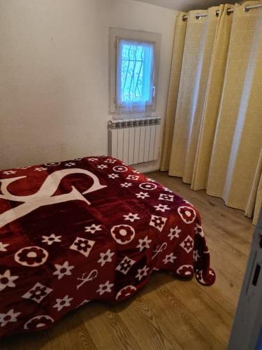 1 dormitorio con una manta roja en el suelo en Maison à 200m de la plage. T3 avec terrasse., en Valras-Plage