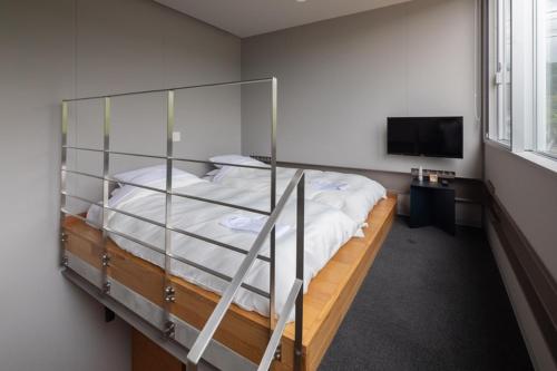 a bedroom with a bunk bed and a television at arita huis in Arita