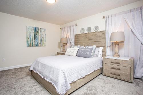 una camera con letto e comodino con lampada di Marvelous 4 Bd w/ Pool Close to Disney 218 a Kissimmee