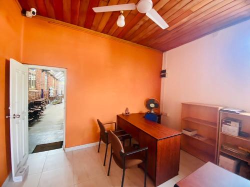 a dining room with a desk and a ceiling fan at Tanty’s Hostel in Galle