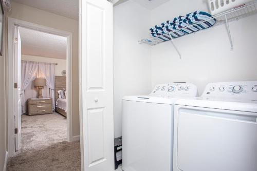 eine weiße Waschküche mit Waschmaschine und Trockner in der Unterkunft Marvelous 4 Bd w/ Pool Close to Disney 218 in Kissimmee