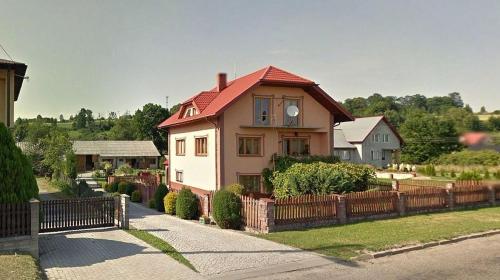 a house with a red roof and a fence at Noclegi Szczebrzeszyn in Szczebrzeszyn